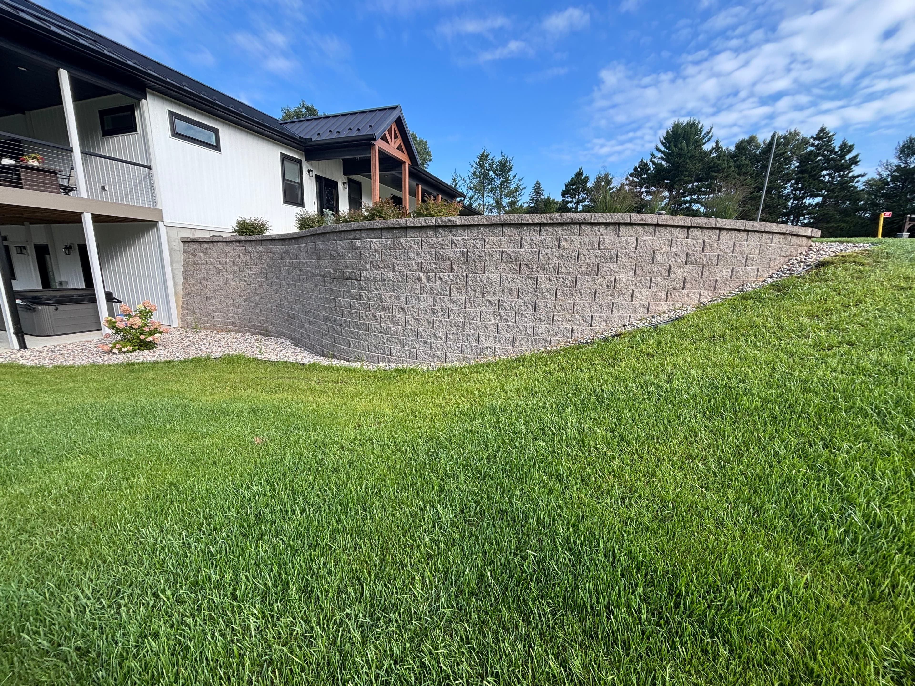 Residential retaining wall with fresh sod installation in Wisconsin Dells, WI